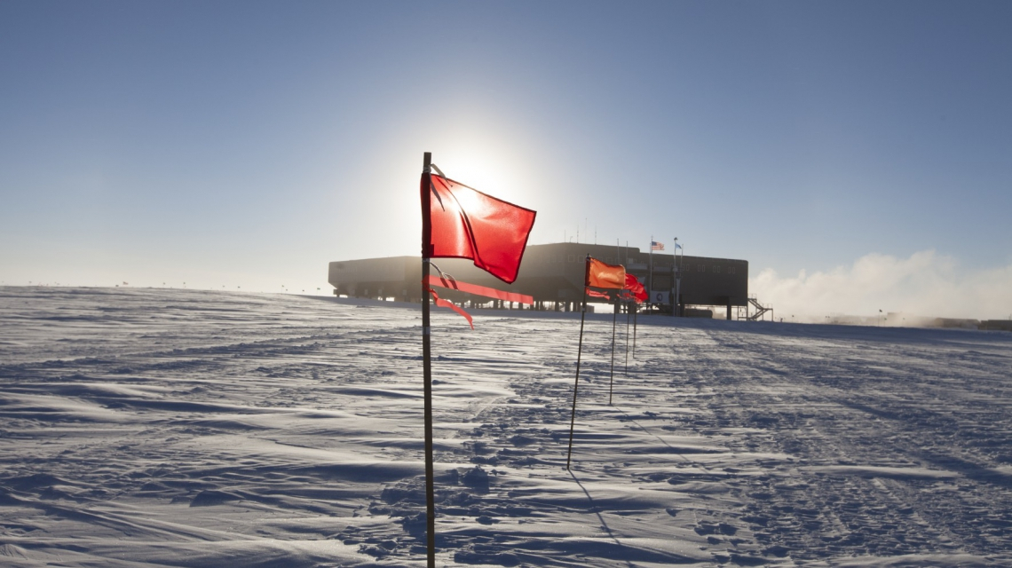 Mit Flaggen markierte Straße vom IceCube Labor zur Südpolstation im Sommer. (Credit: Freija Descamps/NSF, 2011)